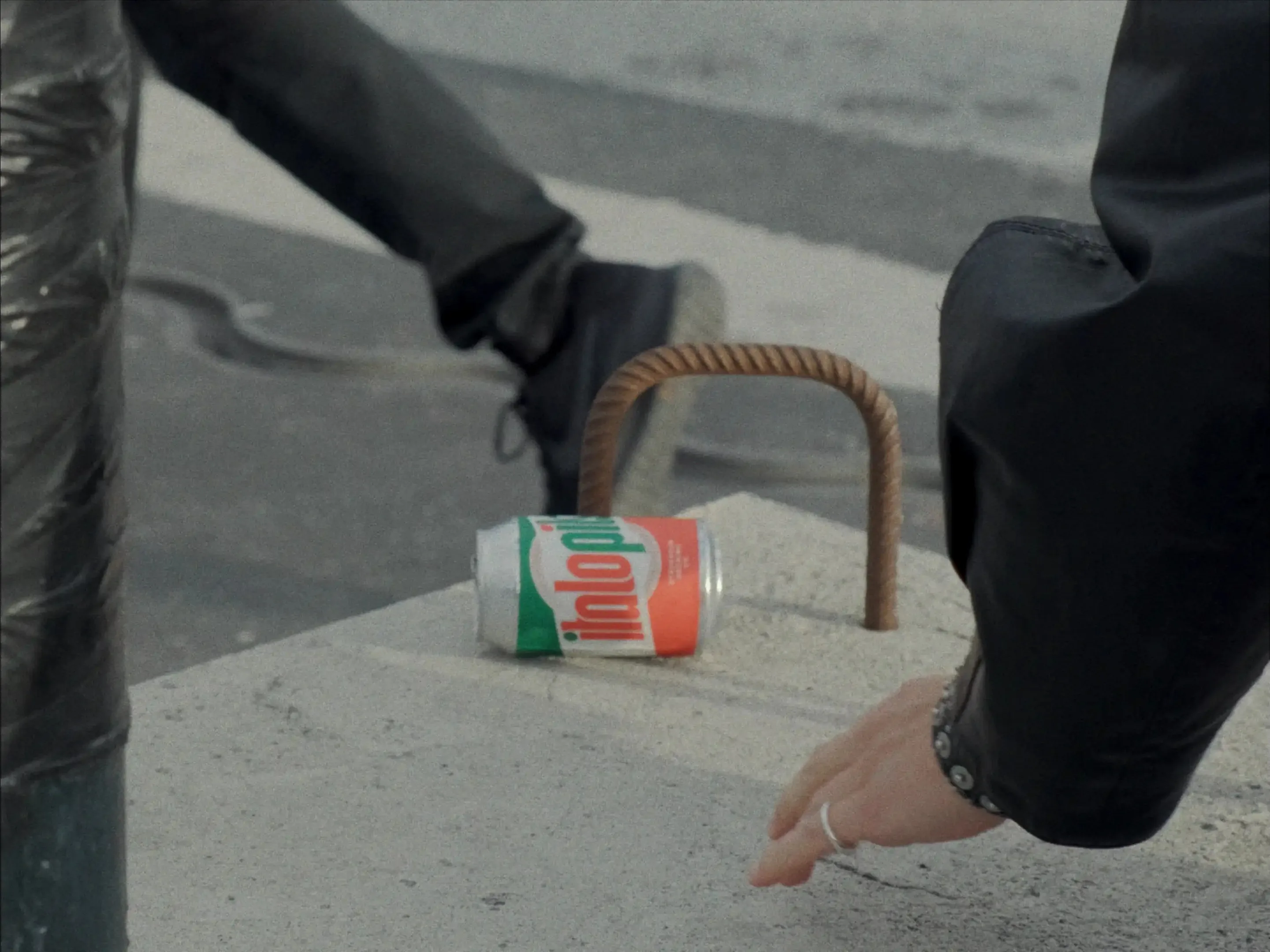 Film still: a can set down on a Stockholm railing